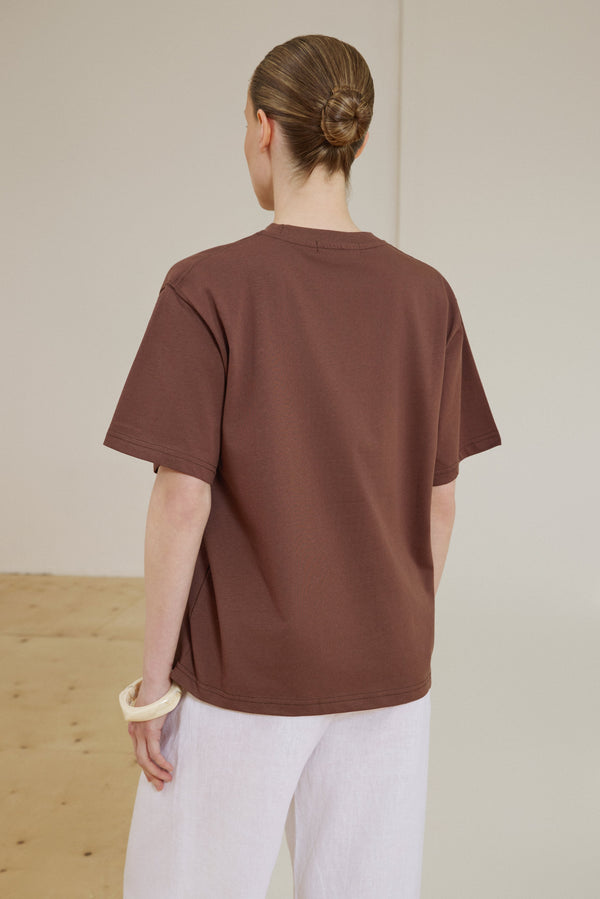 Back of women's dark brown boxy-style T-shirt.