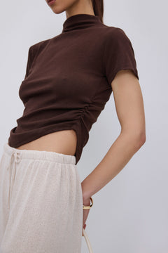 Side profile of dark brown T-shirt with ruched detail.
