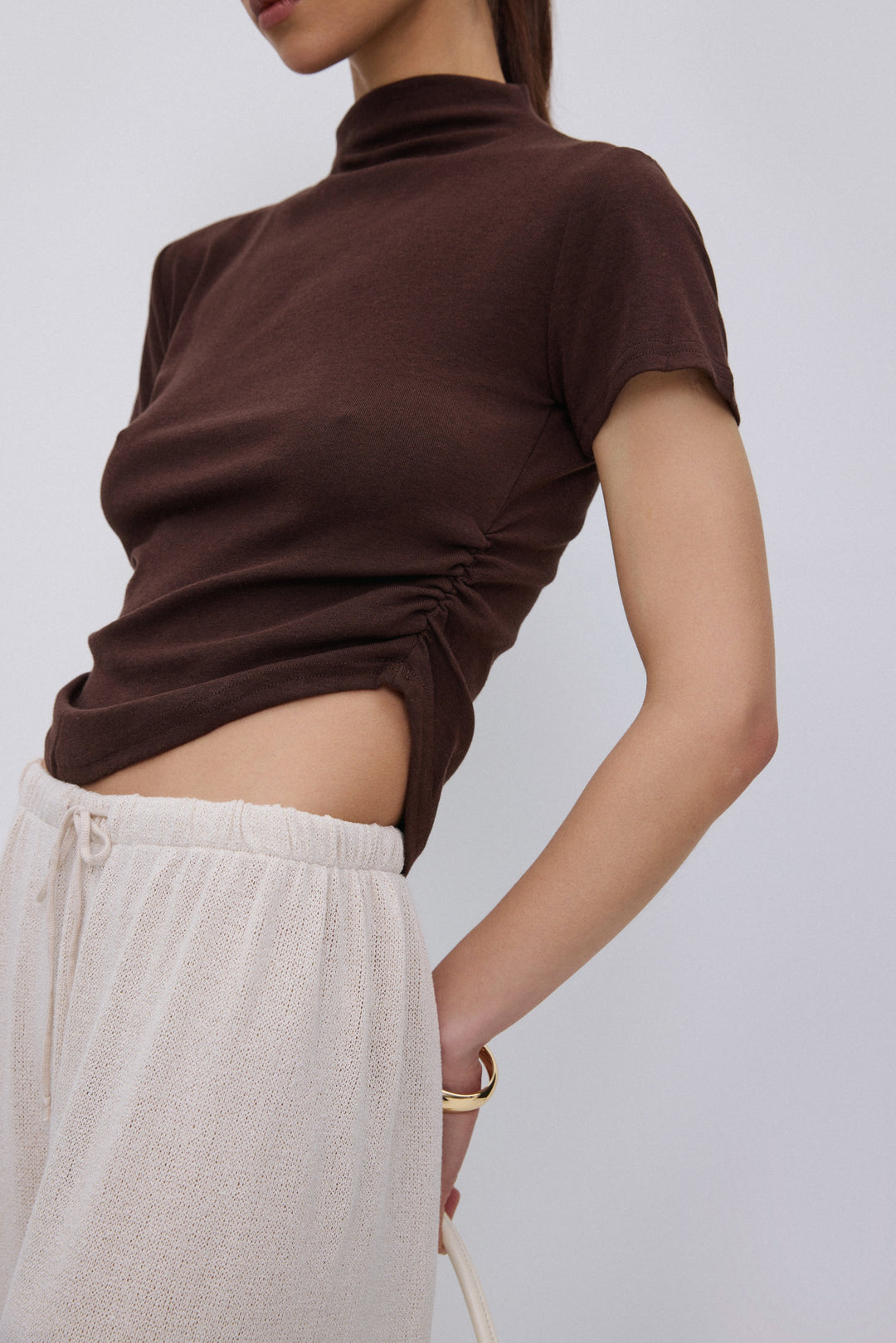 Side profile of dark brown T-shirt with ruched detail.