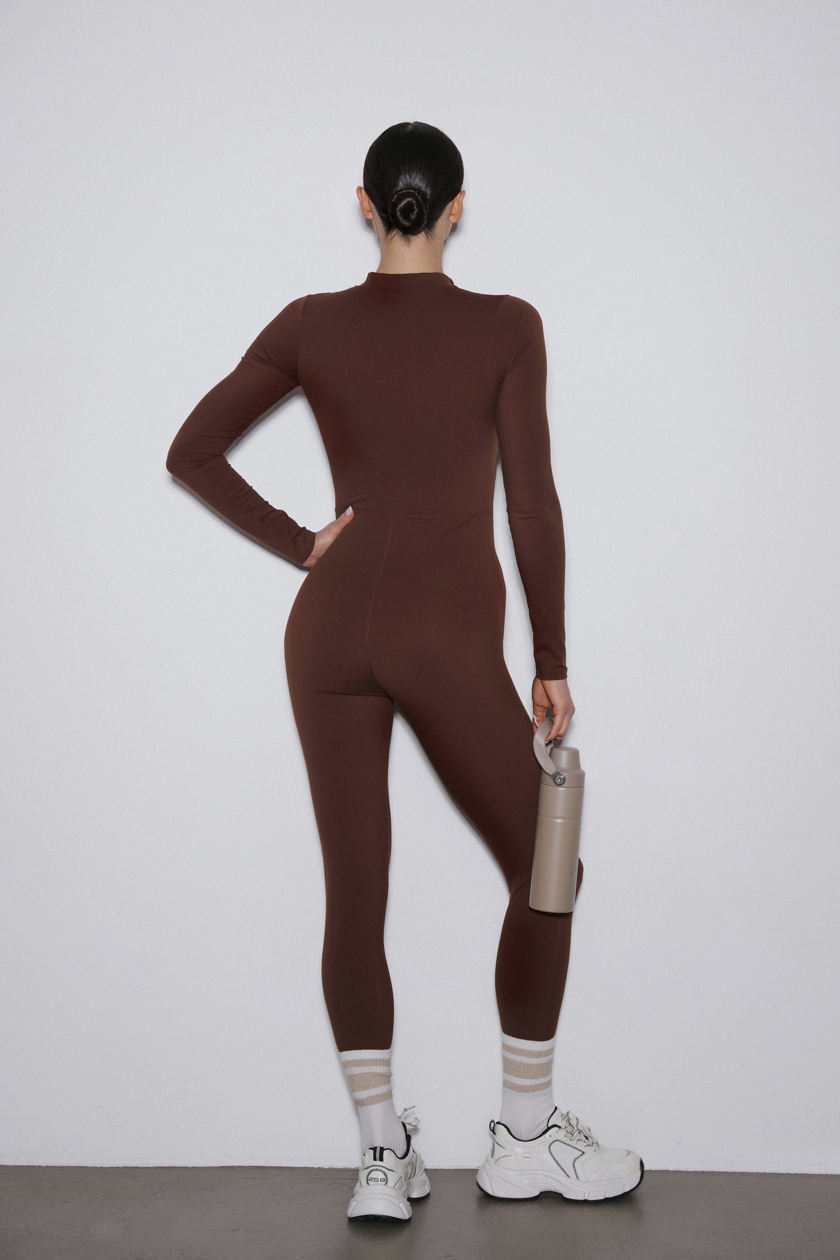 Back of dark brown slim fit sporty jumpsuit.