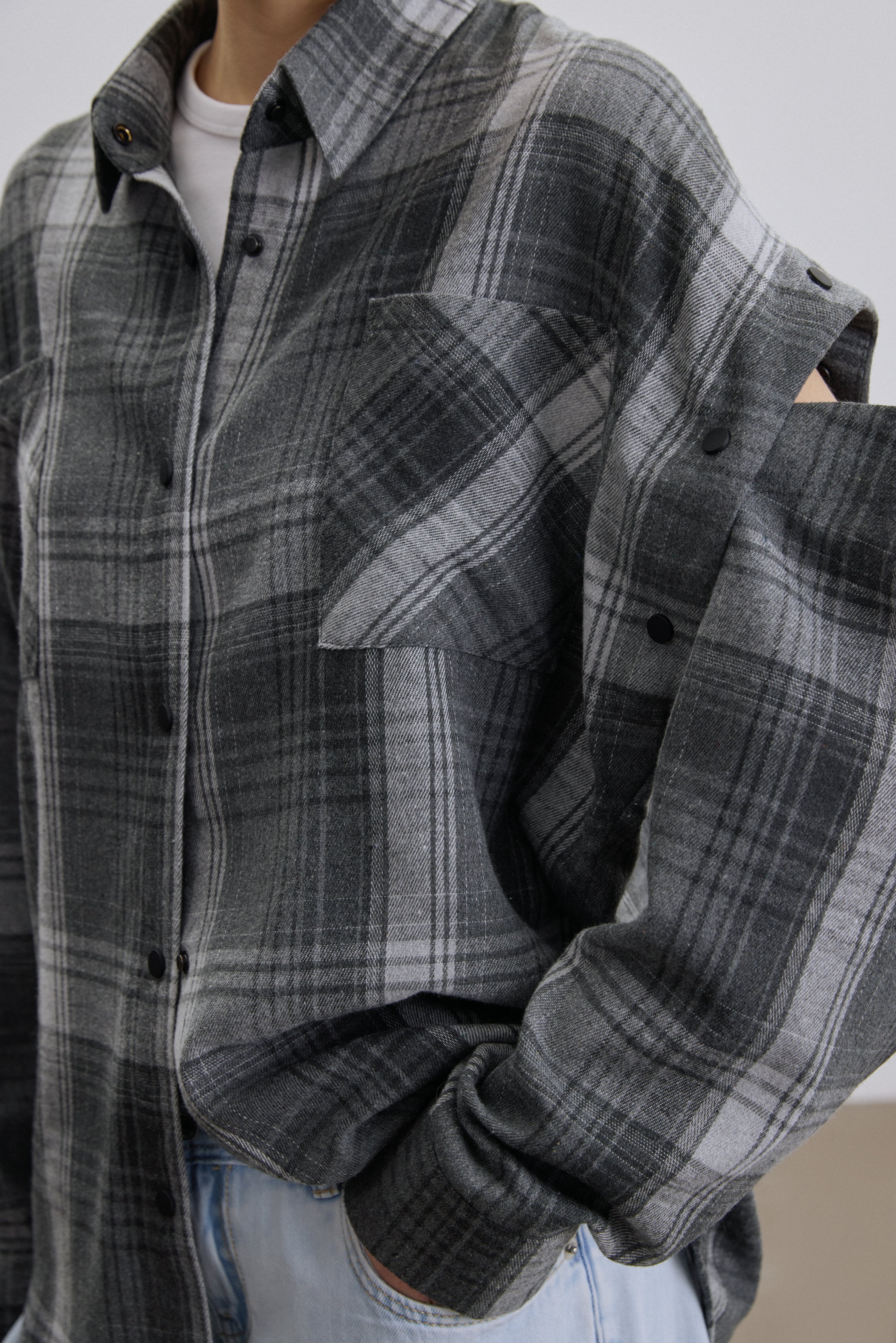 Close-up of buttons for detachable sleeves on grey shirt.
