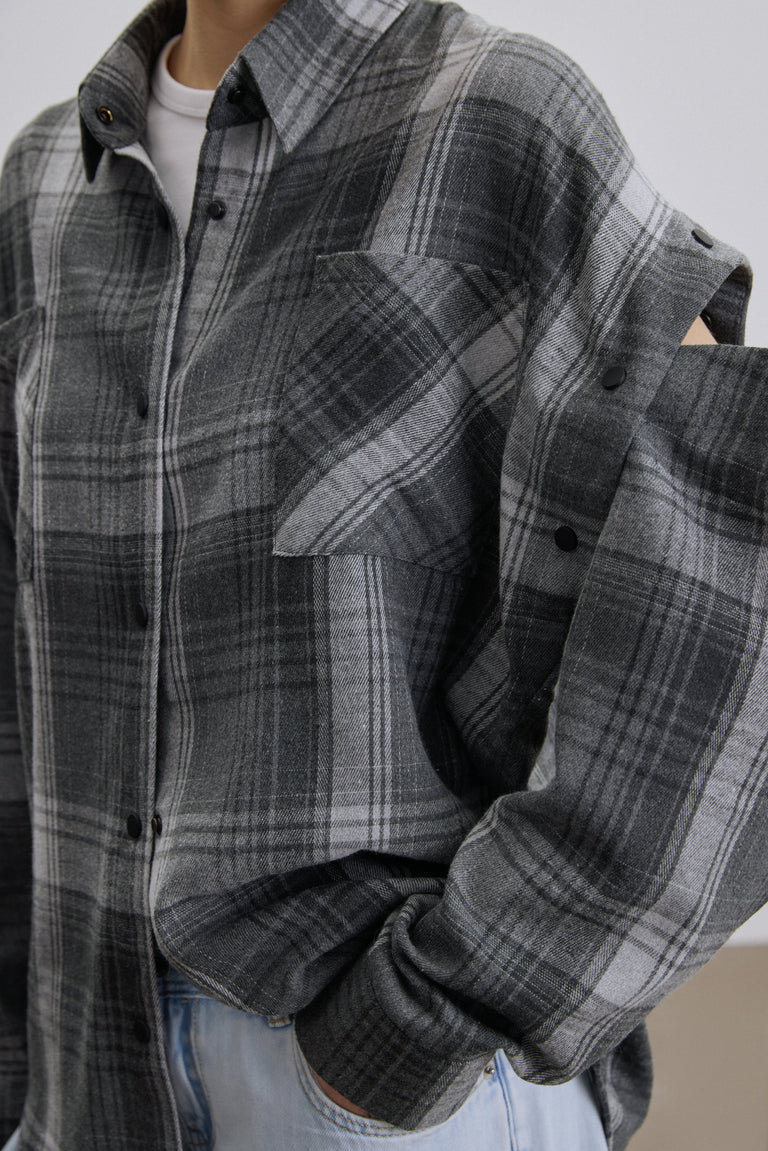 Close-up of buttons for detachable sleeves on grey shirt.