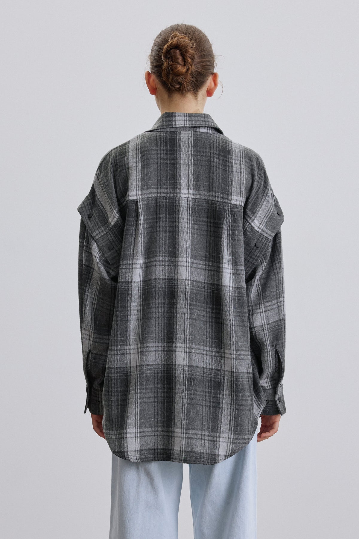 Back of women’s grey checkered shirt.