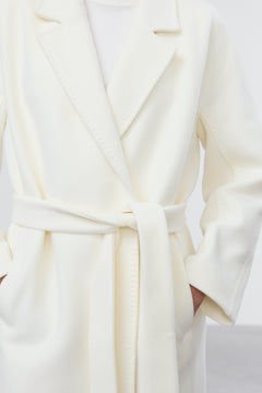 Model wearing Estro milky beige belted coat.