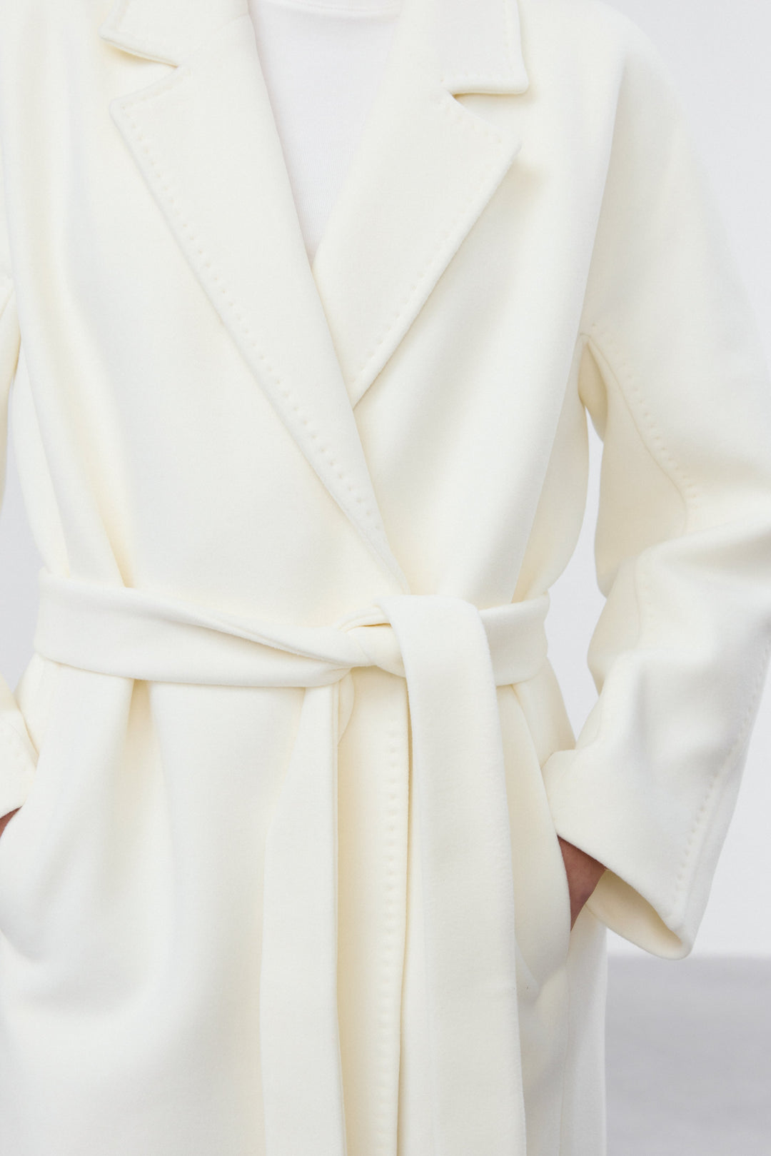 Model wearing Estro milky beige belted coat.