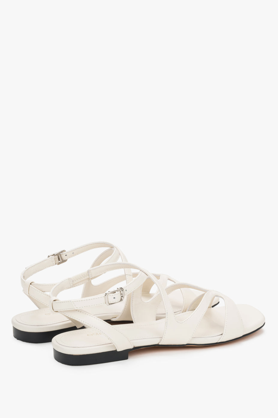 Strappy sandals with flat sole and milky beige finish.