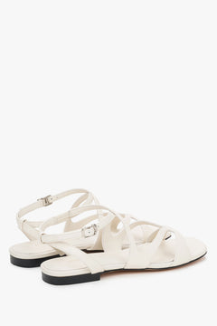 Strappy sandals with flat sole and milky beige finish.