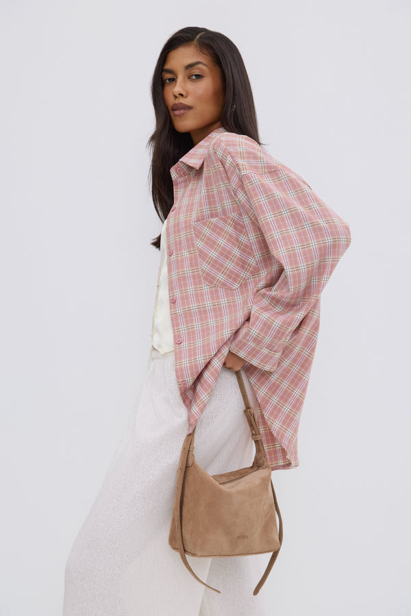 Model wearing Estro light pink plaid button-up shirt.
