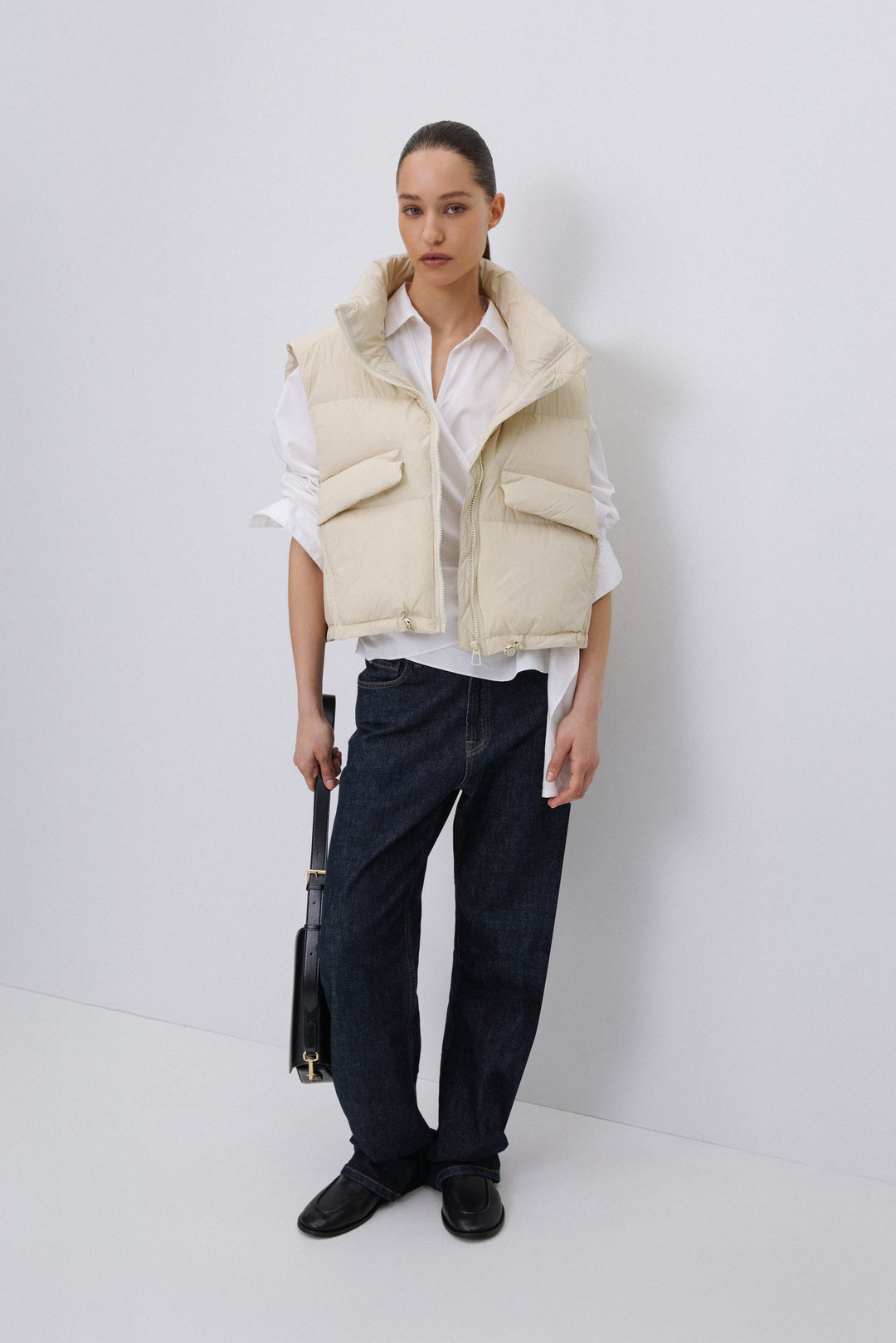 Model wearing Estro short light beige puffer vest.