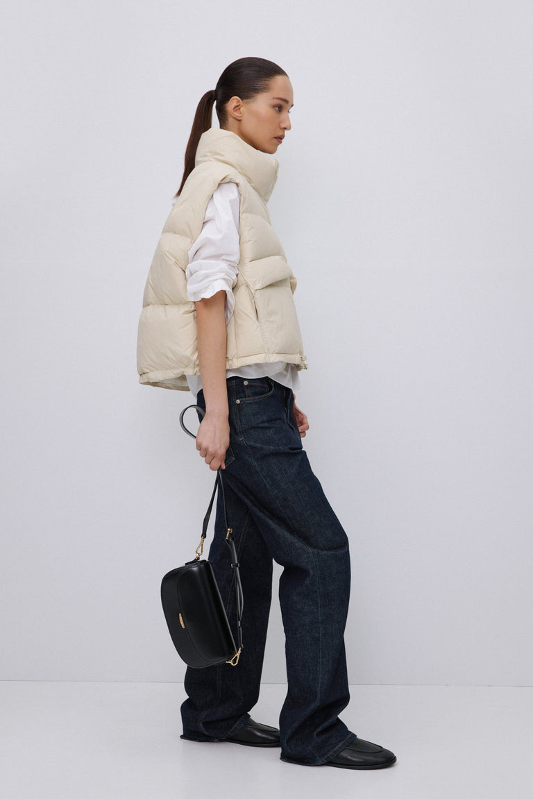 Side profile of light beige quilted puffer vest.