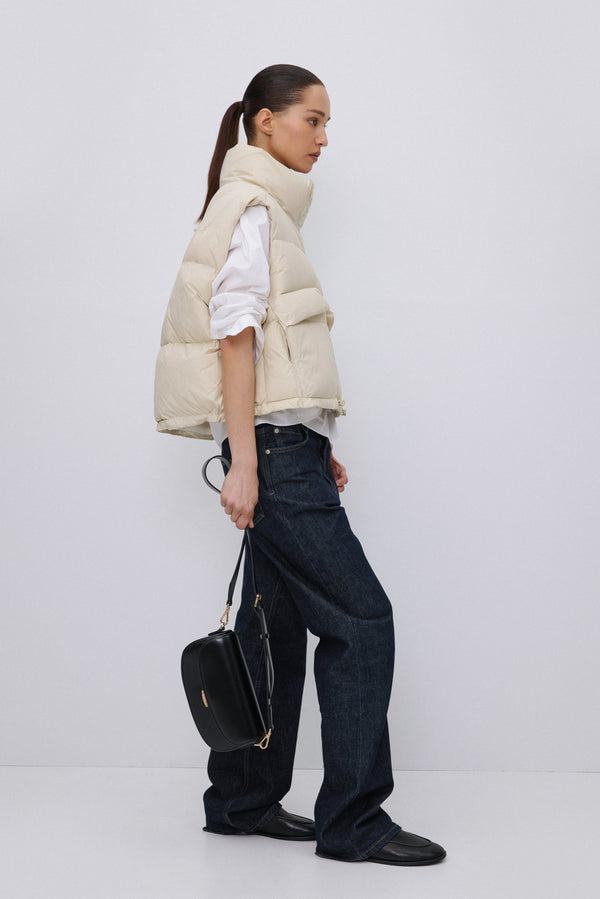 Side profile of light beige quilted puffer vest.