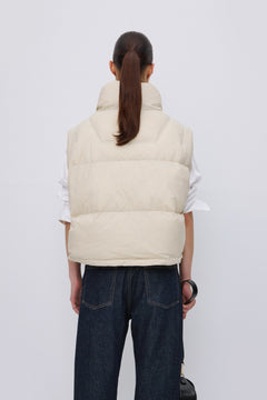 Back of women's short light beige down vest.