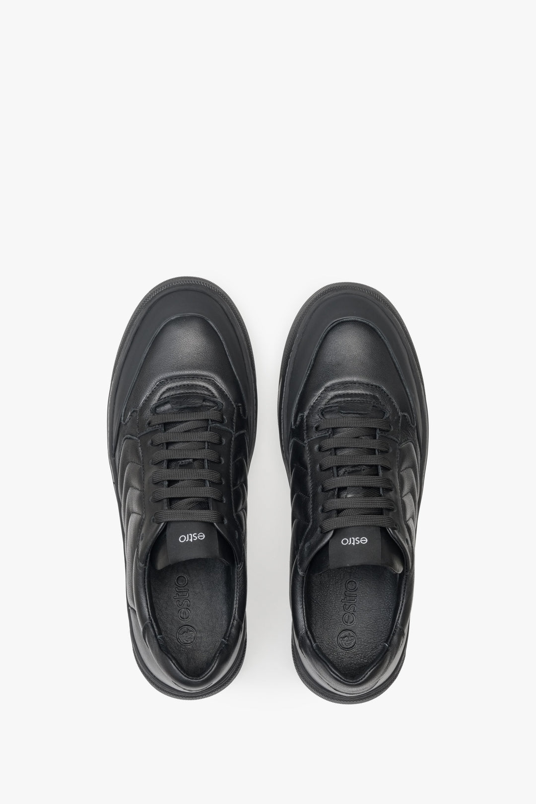 Low, lace-up men's sneakers made from genuine black leather by Estro - close-up of the upper part of the shoes.
