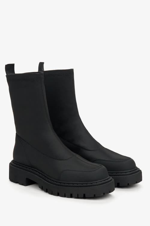 Black slip-on women's ankle boots with a flexible upper - close-up of the shoe's toe and side seam.