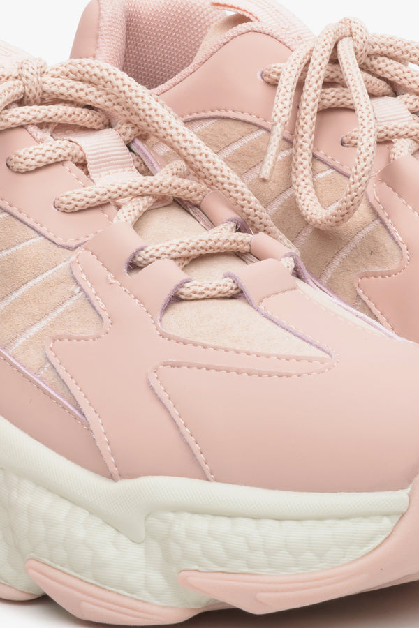 Women's sneakers in light pink with suede and textile elements on a thick sole - close-up on the details.