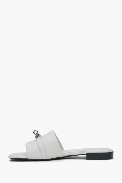 Stylish white Estro women's slide sandals, featuring a subtle silver embellishment and offering comfort thanks to the flat heel.