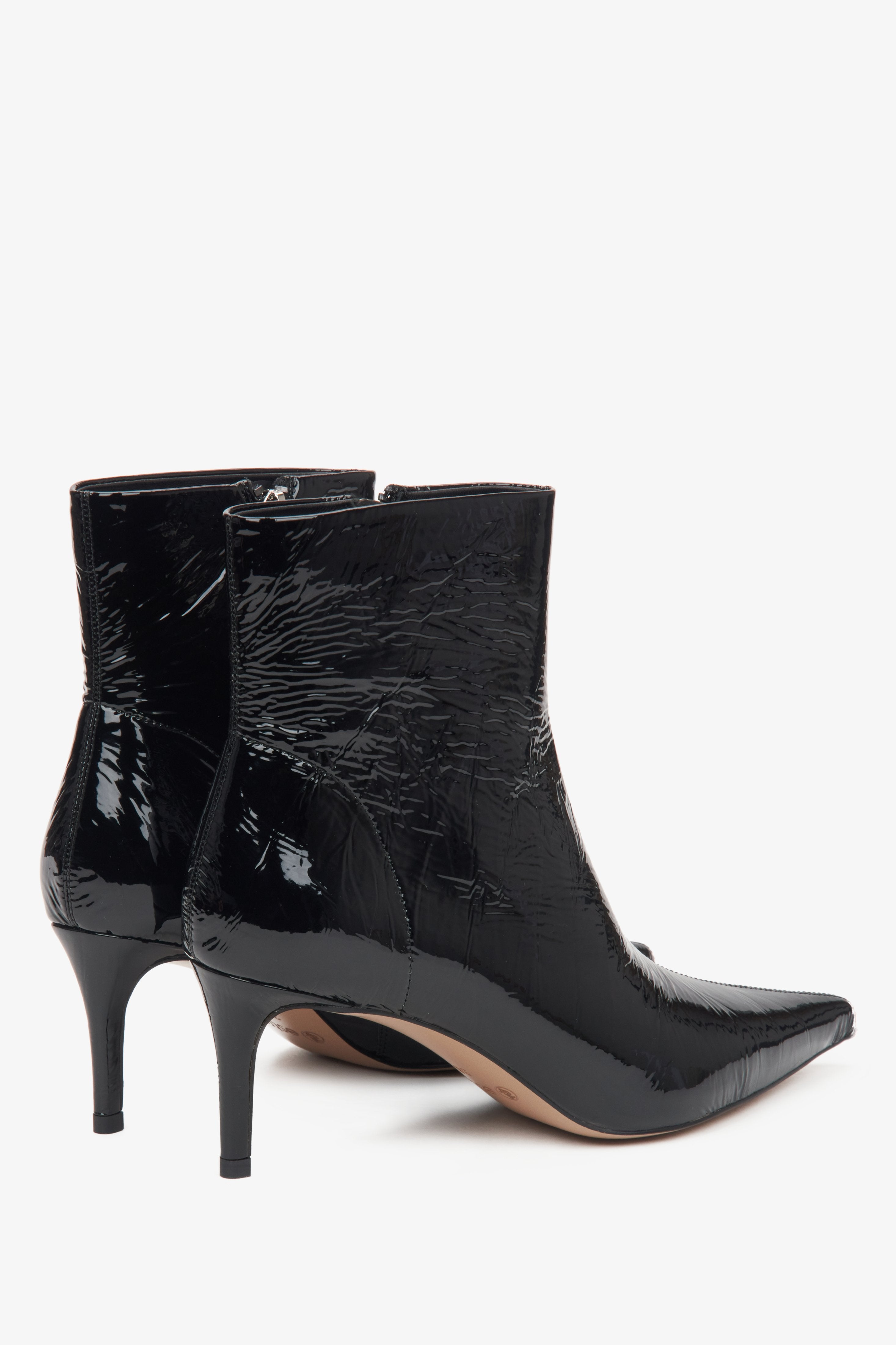 Black women's ankle boots by Estro made of patent natural leather – close-up of the heel and side line of the shoe.