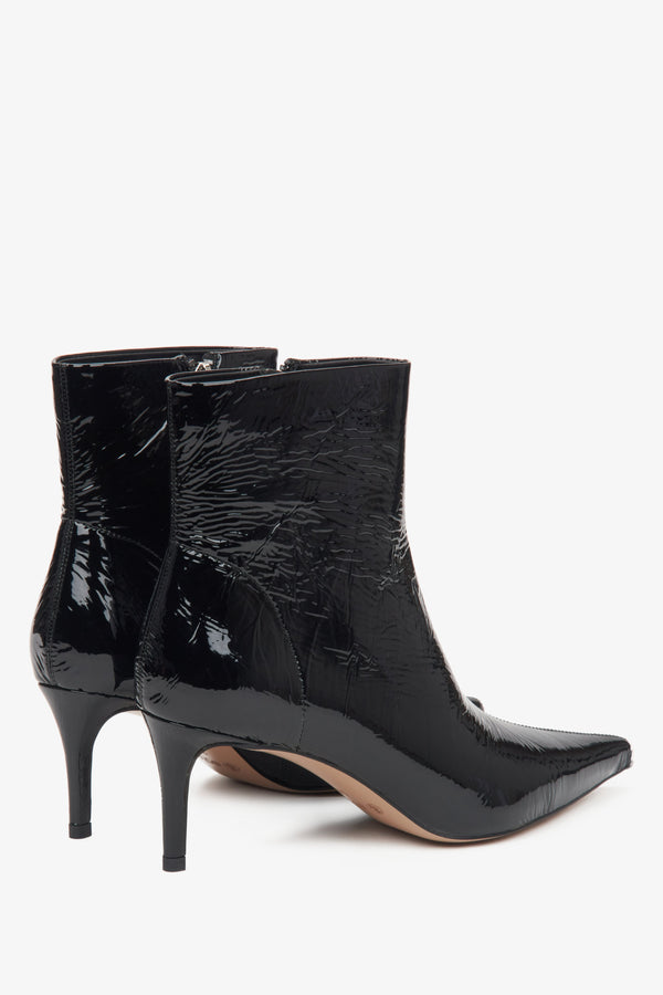 Black women's ankle boots by Estro made of patent natural leather – close-up of the heel and side line of the shoe.