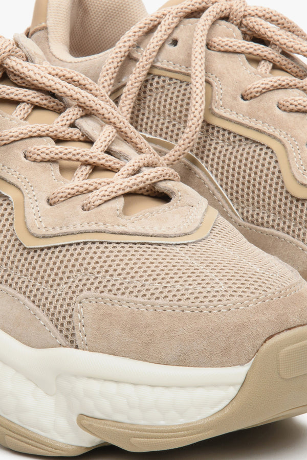 Beige women's sneakers with suede and textile on a chunky sole - close-up on the details.