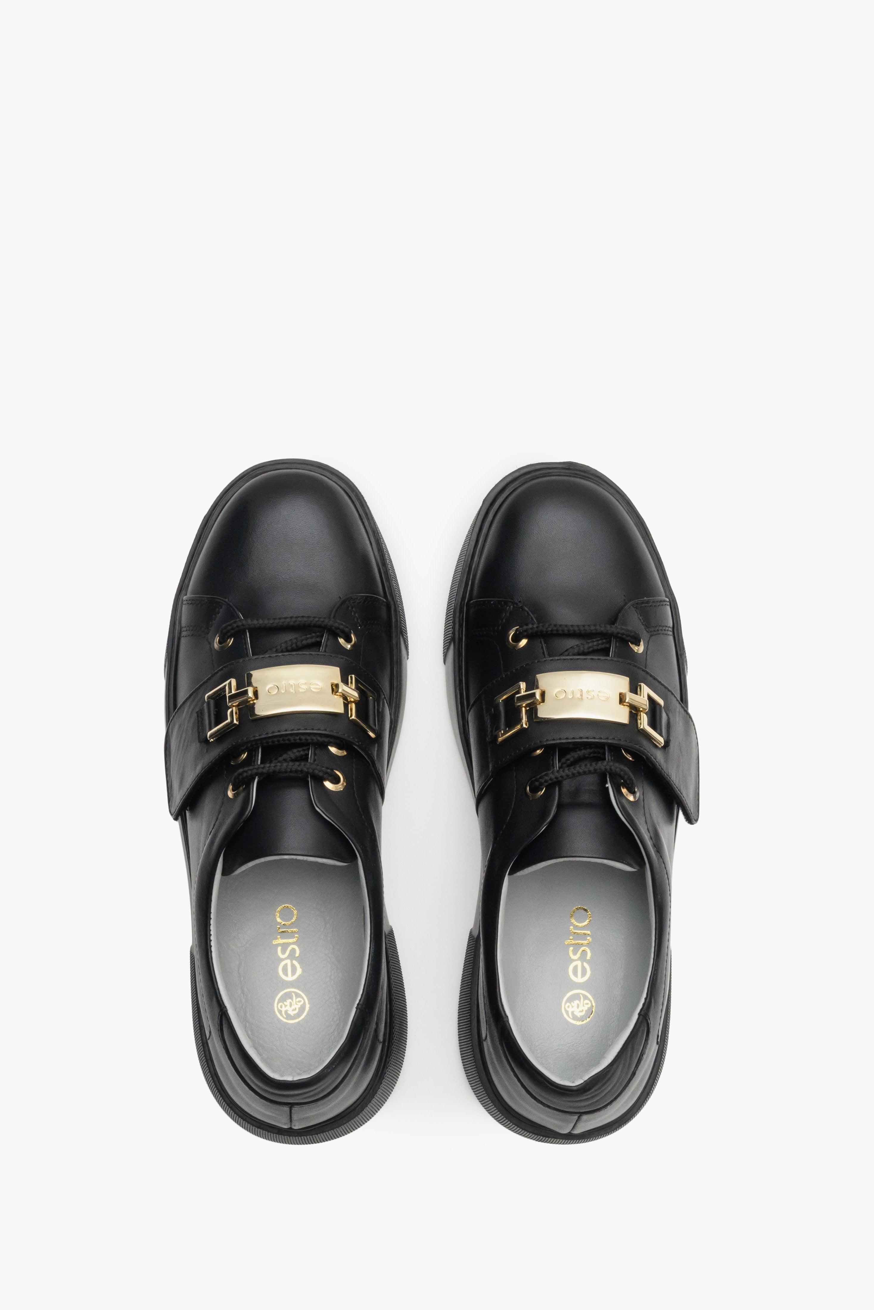 Women's black sneakers made of genuine leather with gold accents - top view shoe presentation.