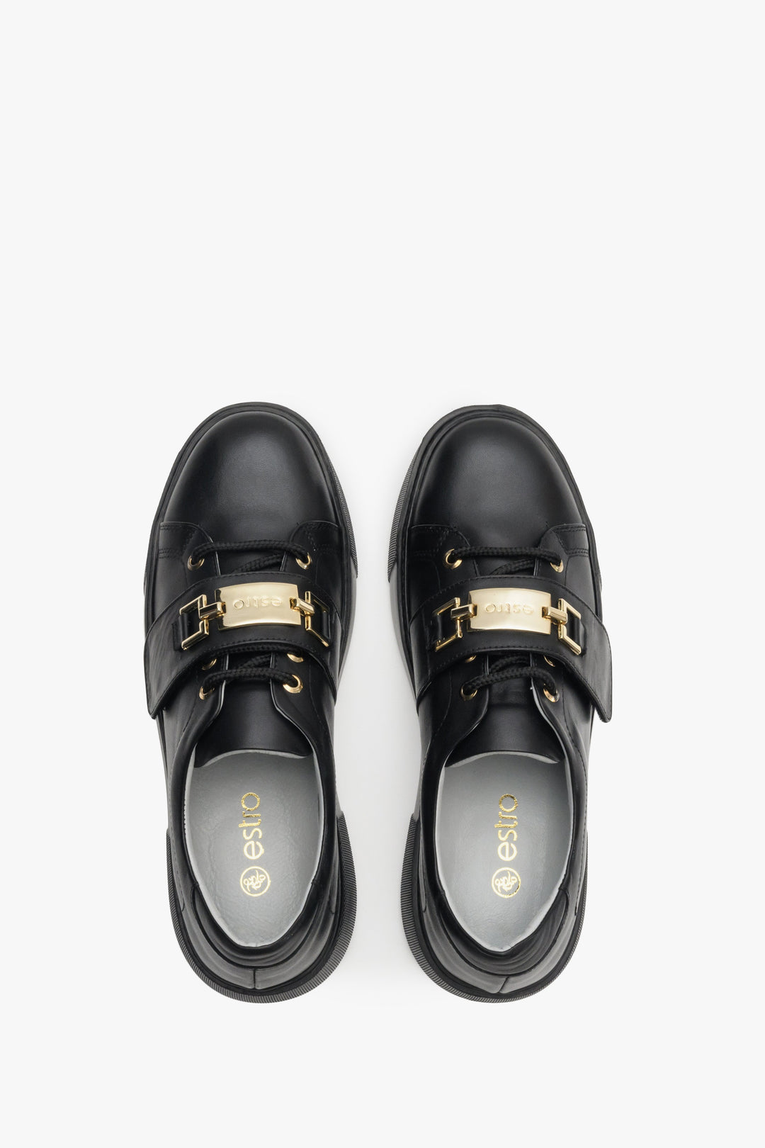 Women's black sneakers made of genuine leather with gold accents - top view shoe presentation.