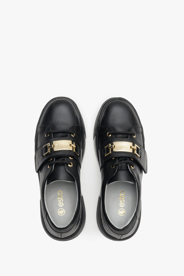 Women's black sneakers made of genuine leather with gold accents - top view shoe presentation.