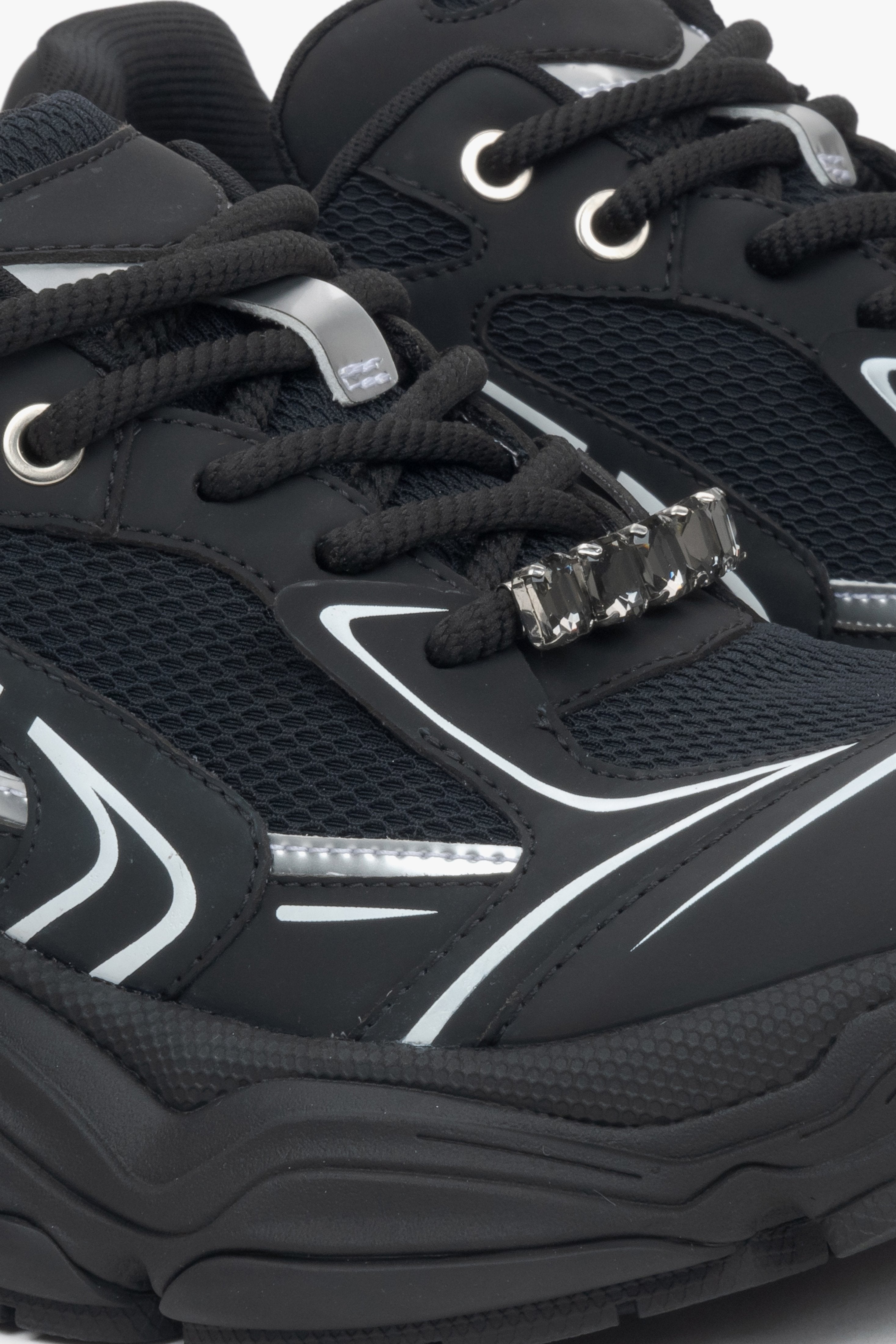 Black women's sneakers with rhinestones on the laces – close-up of the lacing system.