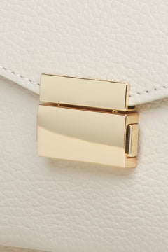 Women's small light beige handbag made of premium Italian genuine leather - close-up on details.