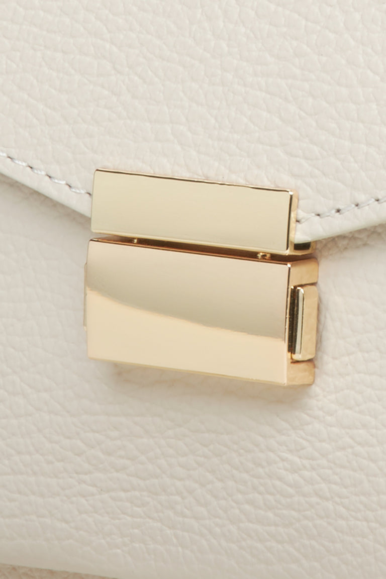 Women's small beige handbag made of premium Italian genuine leather - close-up on details.