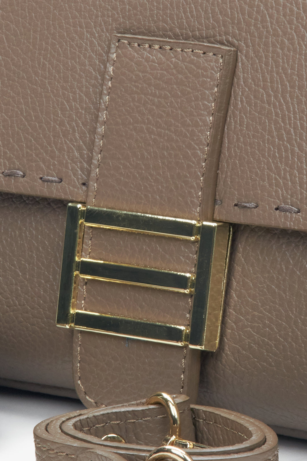 Women's handbag made of Italian genuine grey leather with golden hardware - close-up on detail.