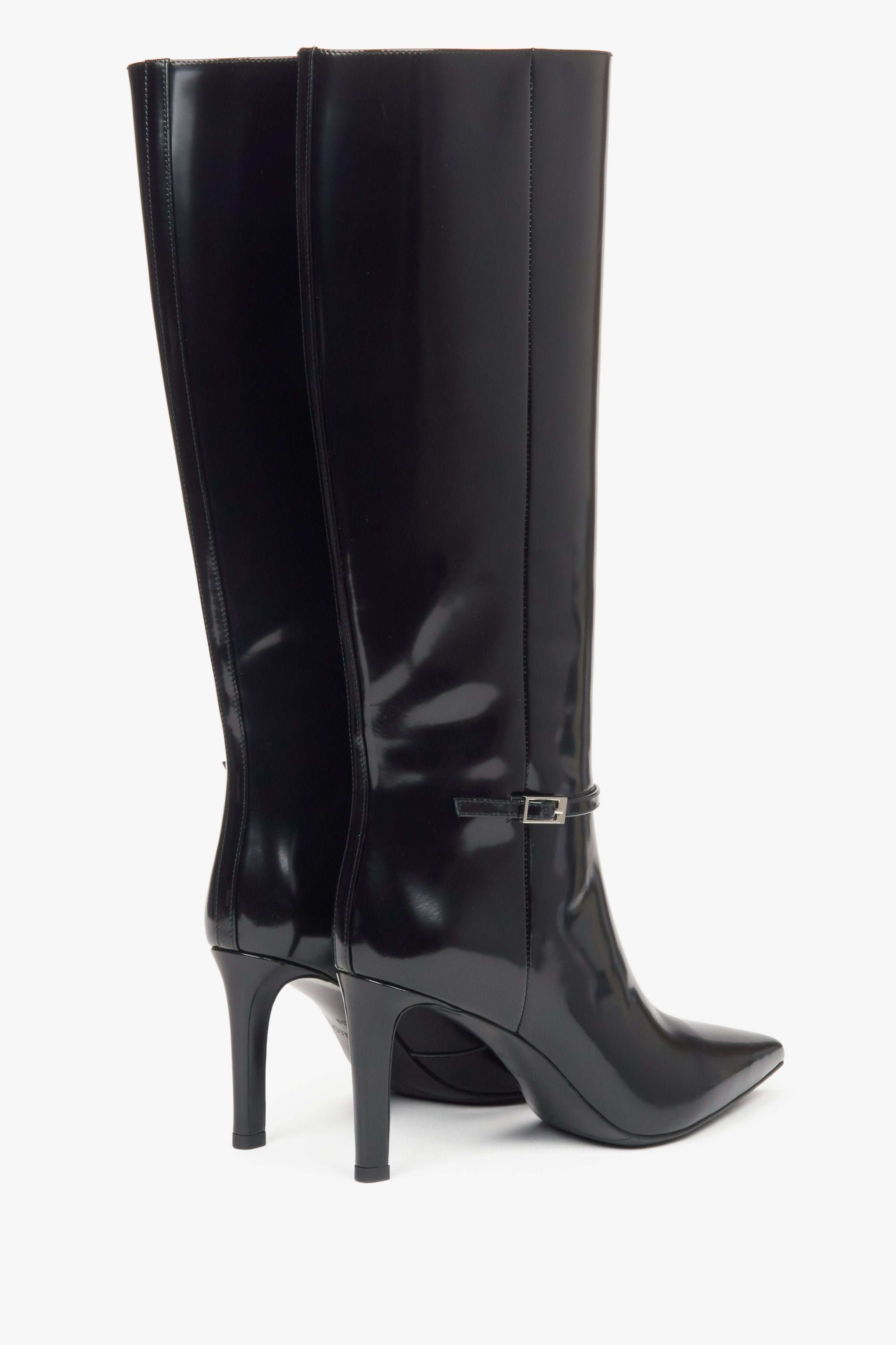 Black knee-high boots with a high heel made of genuine patent leather from Estro - close-up of the heel and the back of the boots.