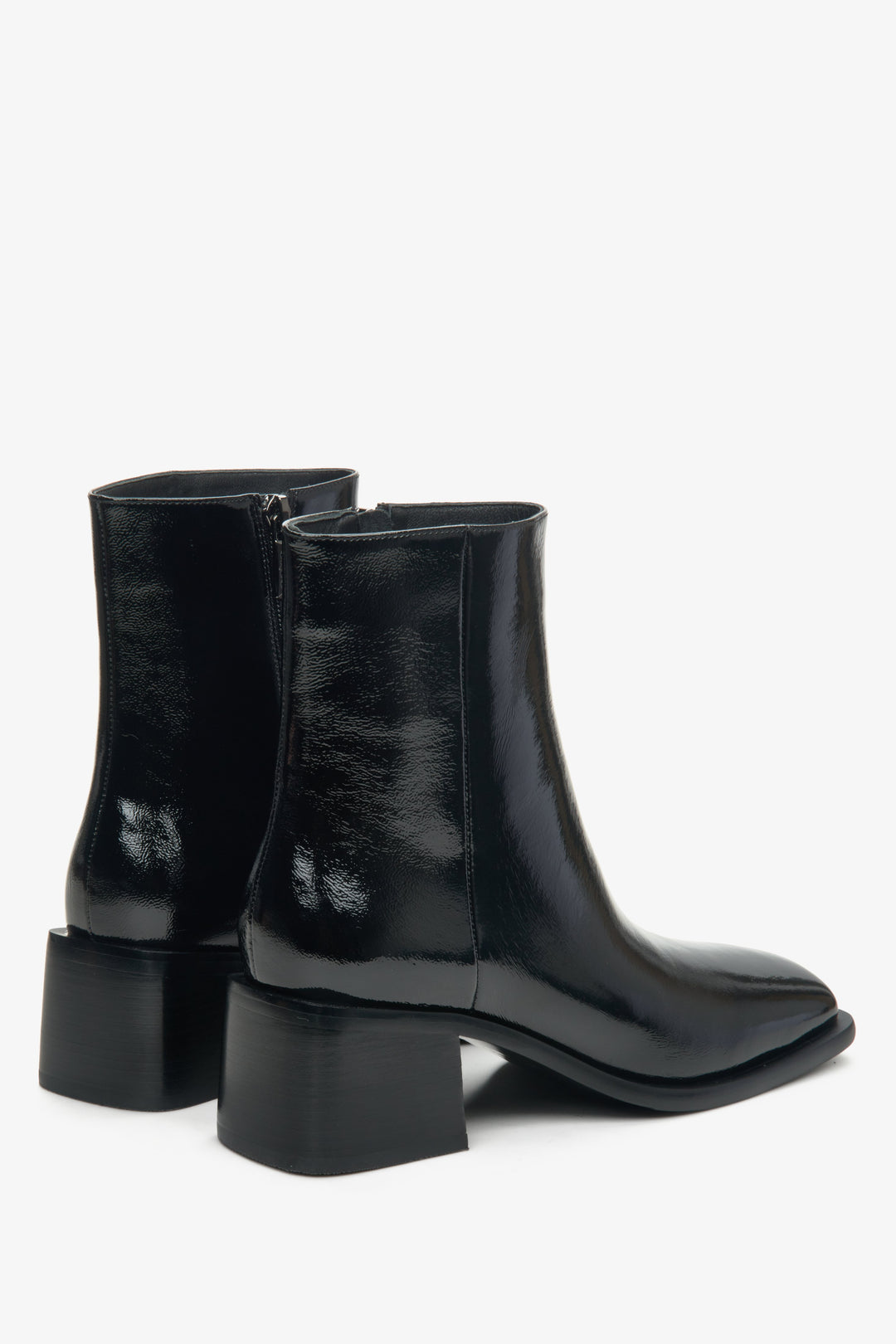 Low-heeled women's boots made of black patent leather by Estro - close-up on the back and side of the model.