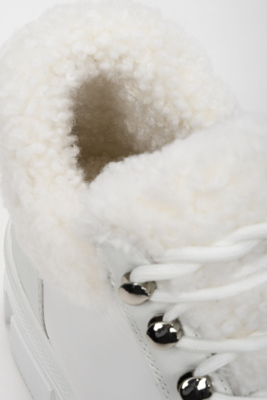 Women's white winter boots made of genuine leather with genuine fur - close-up on details.