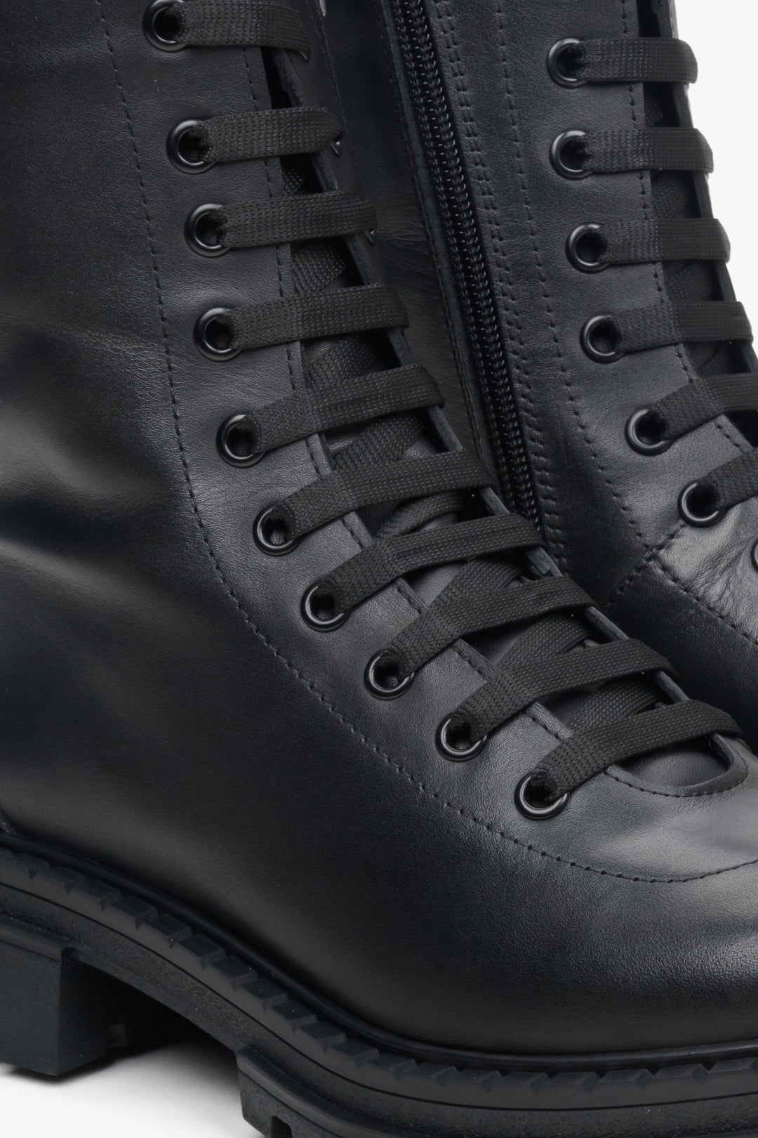 Women's black leather ankle boots with decorative lacing by Estro - close-up on details.