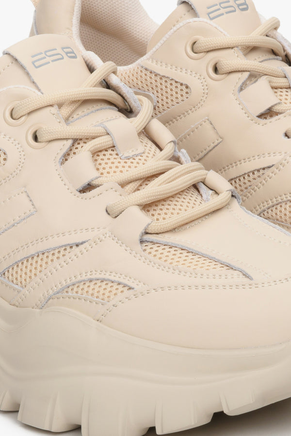 Women's beige sneakers made of genuine leather - close-up of the stitching system and shoe details.