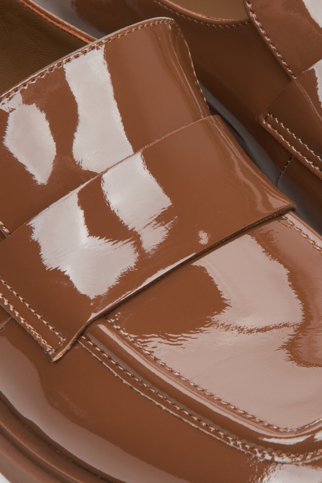 Women's brown patent leather moccasins by Estro - close-up on details.