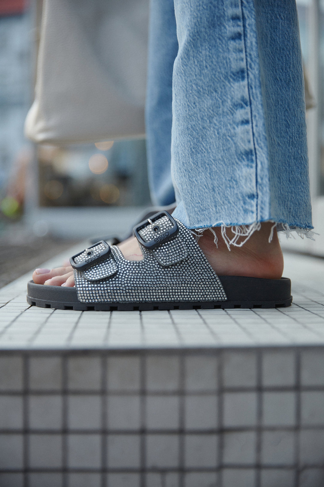 Women's black flip-flops with decorative rhinestones by Estro - presentation on a model.