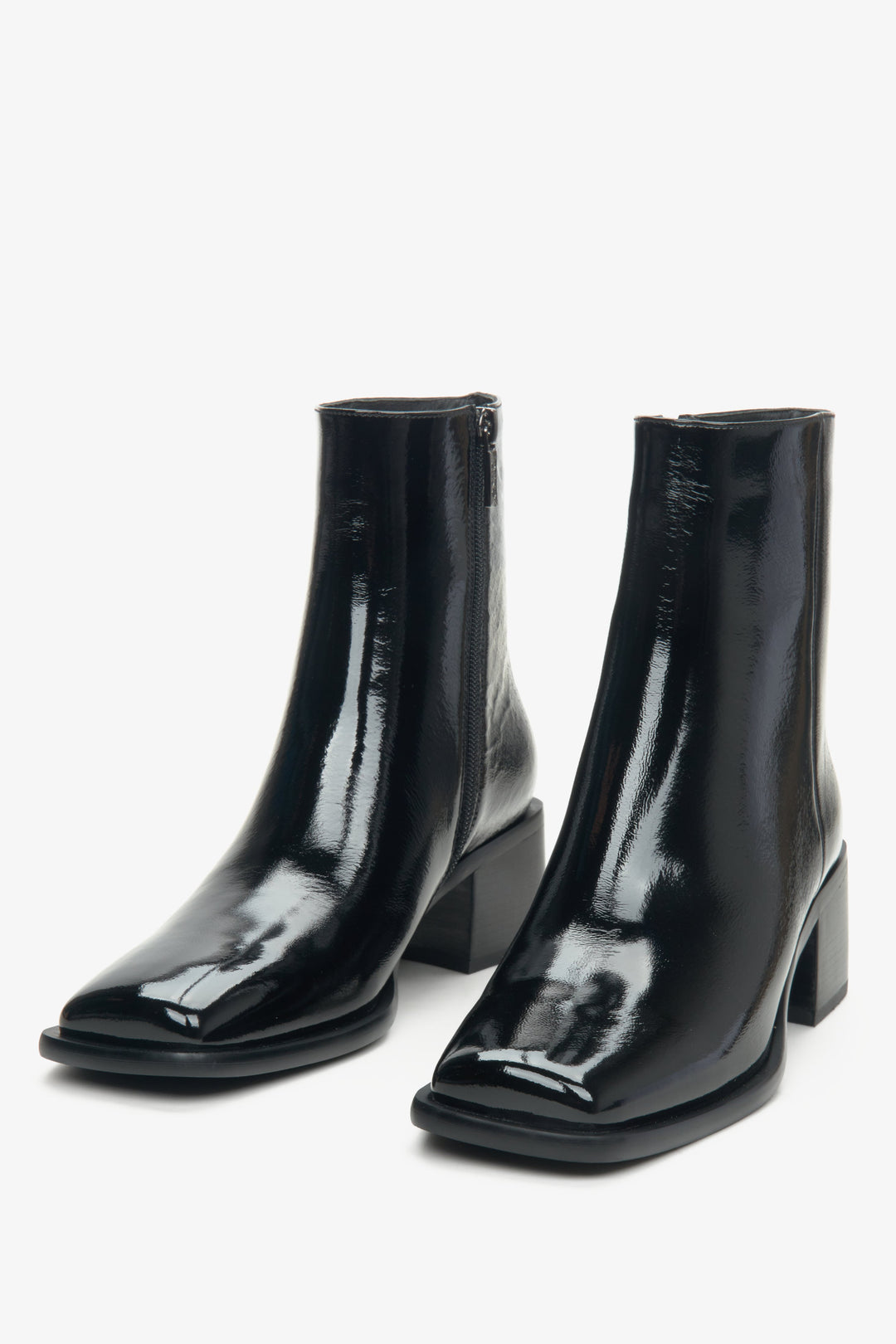 Elegant women's ankle boots made of black patent leather by Estro - close-up on the front of the boot.