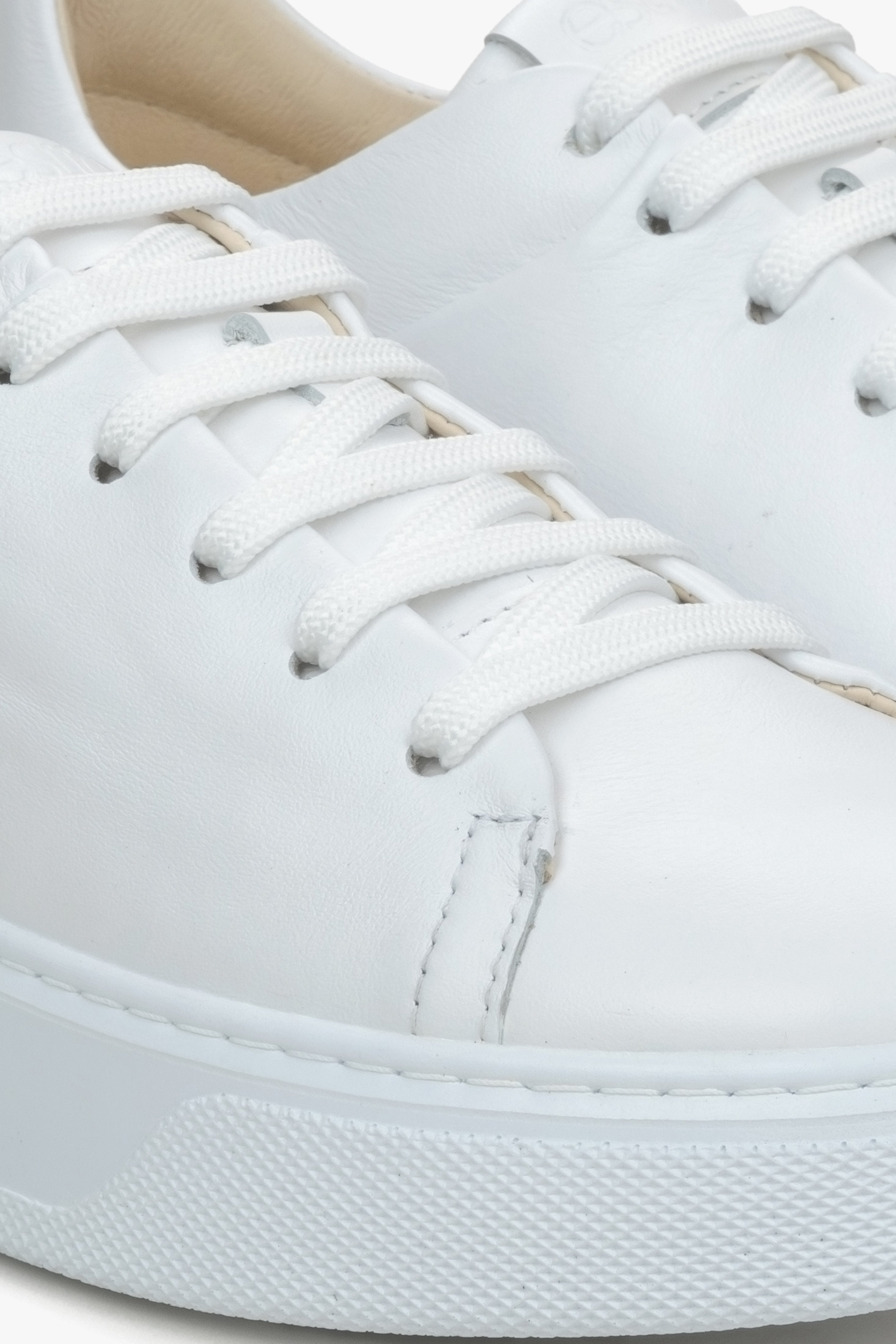 Close-up on details of white women's sneakers made of genuine leather Estro.