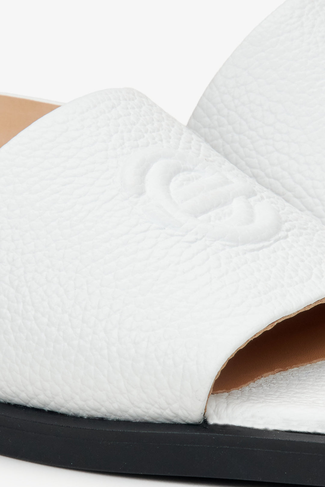 Women's white flip-flops made of genuine leather by Estro - close-up on the details.