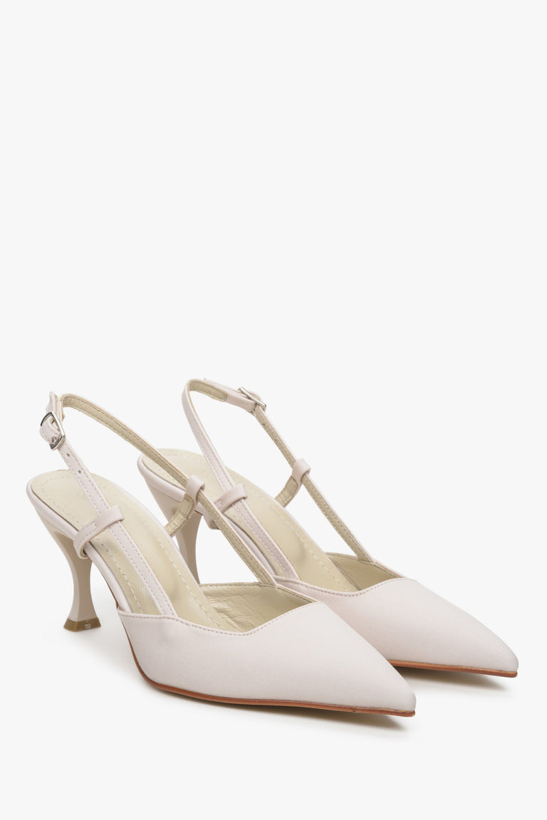 Women's light beige slingback shoes on a funnel heel.