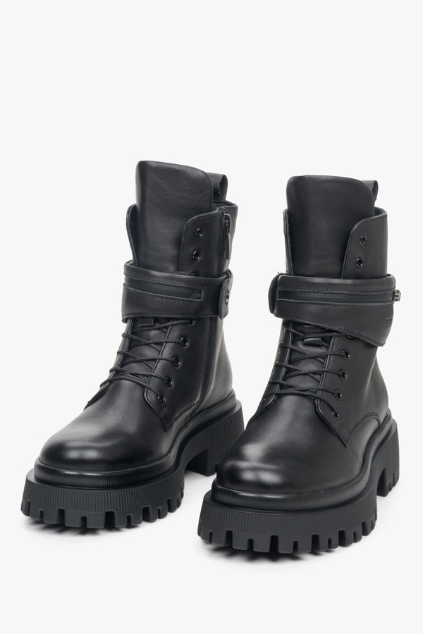 Estro high women's boots made of black genuine leather with lacing, zipper and decorative belt - close-up of the front of the shoes.