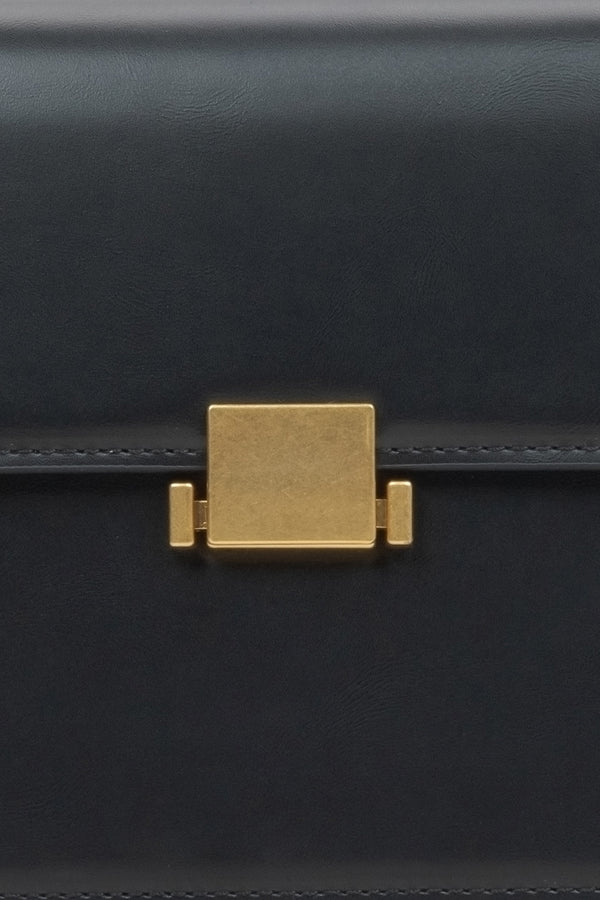 Women's black handbag - close-up of the snap closure.