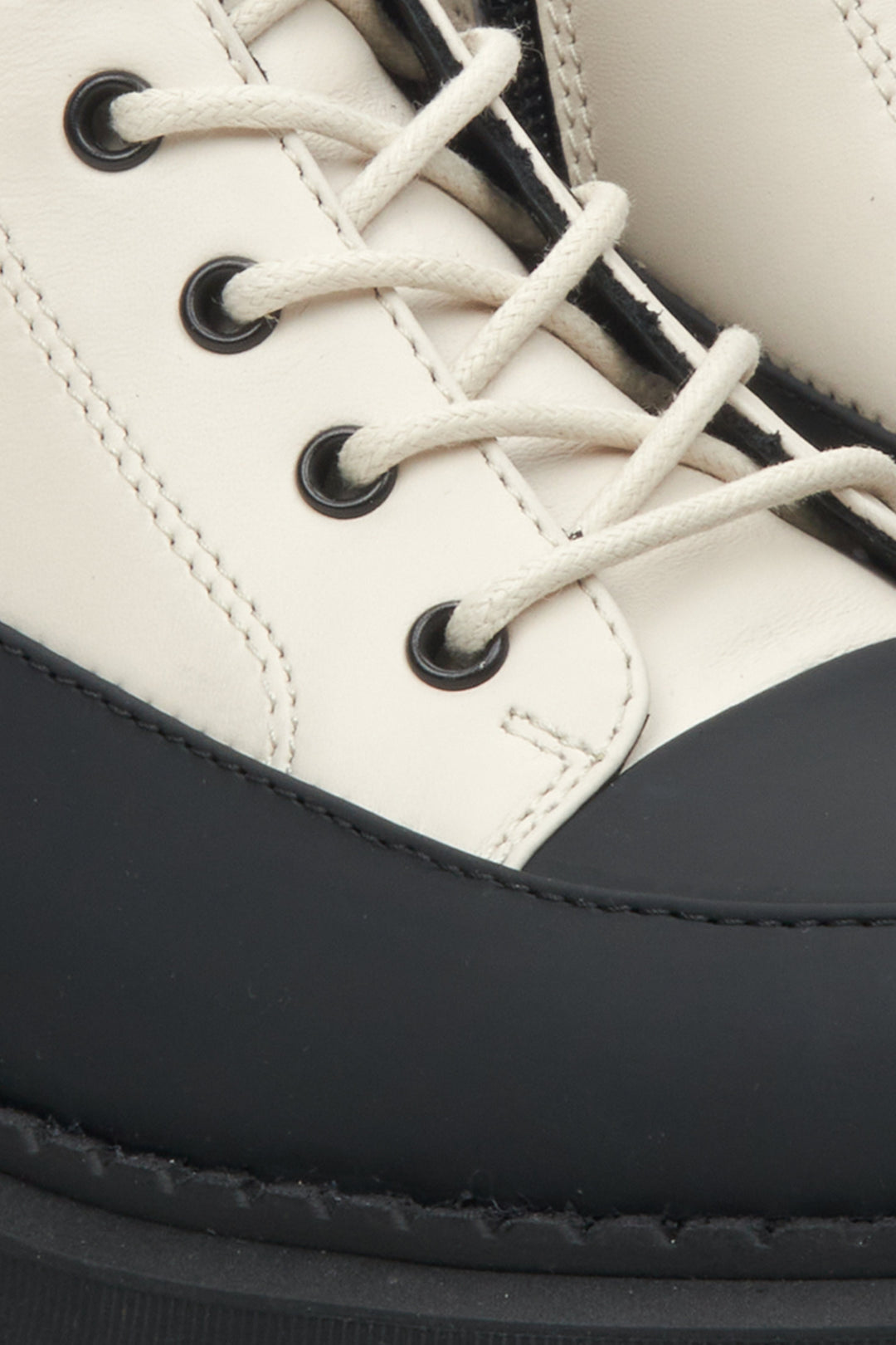 Women's leather Estro ankle boots in beige and black with decorative lacing - close-up on the details.