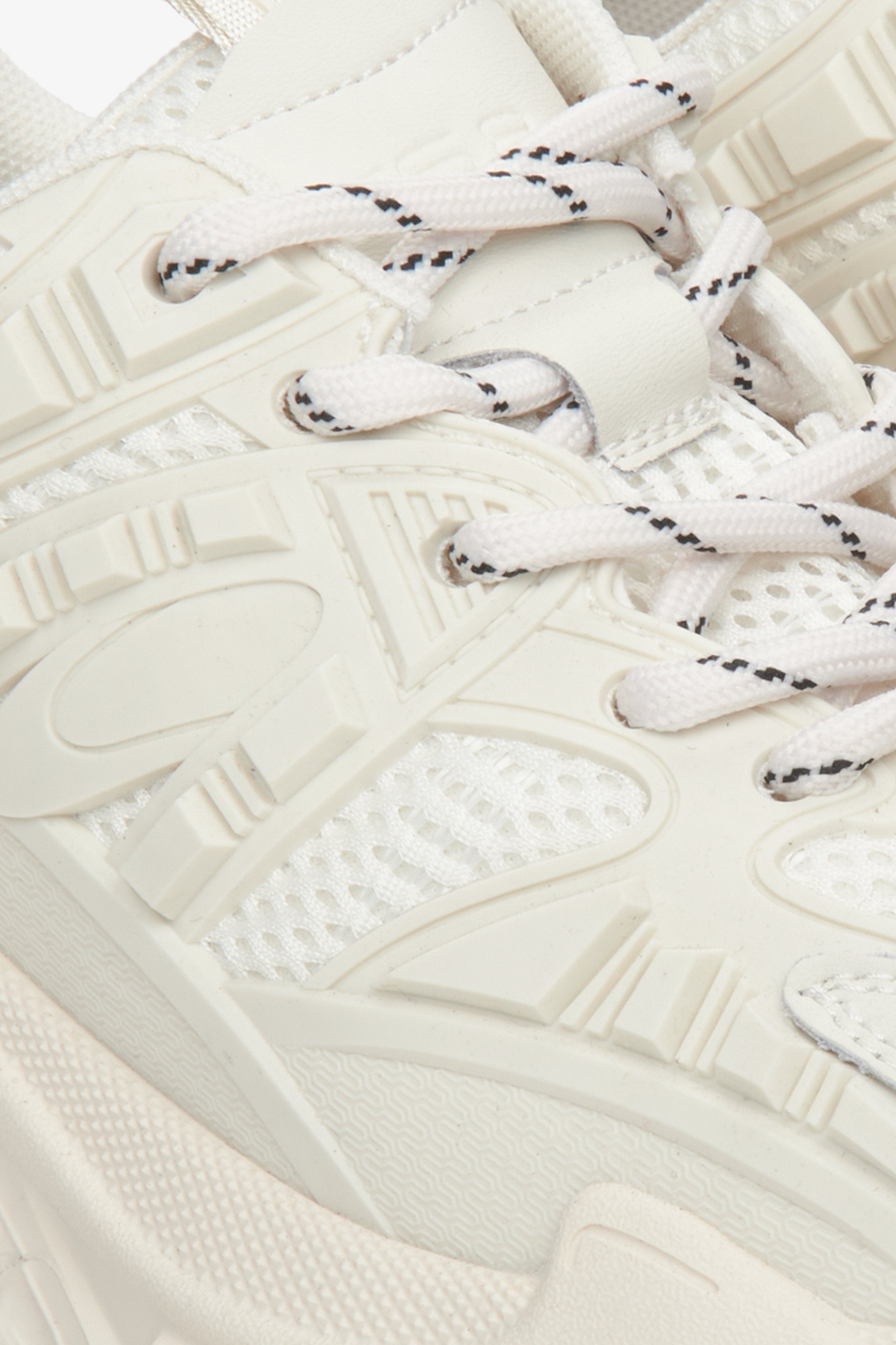 Women's beige leather sneakers with laces - close-up on the shoe lacing.