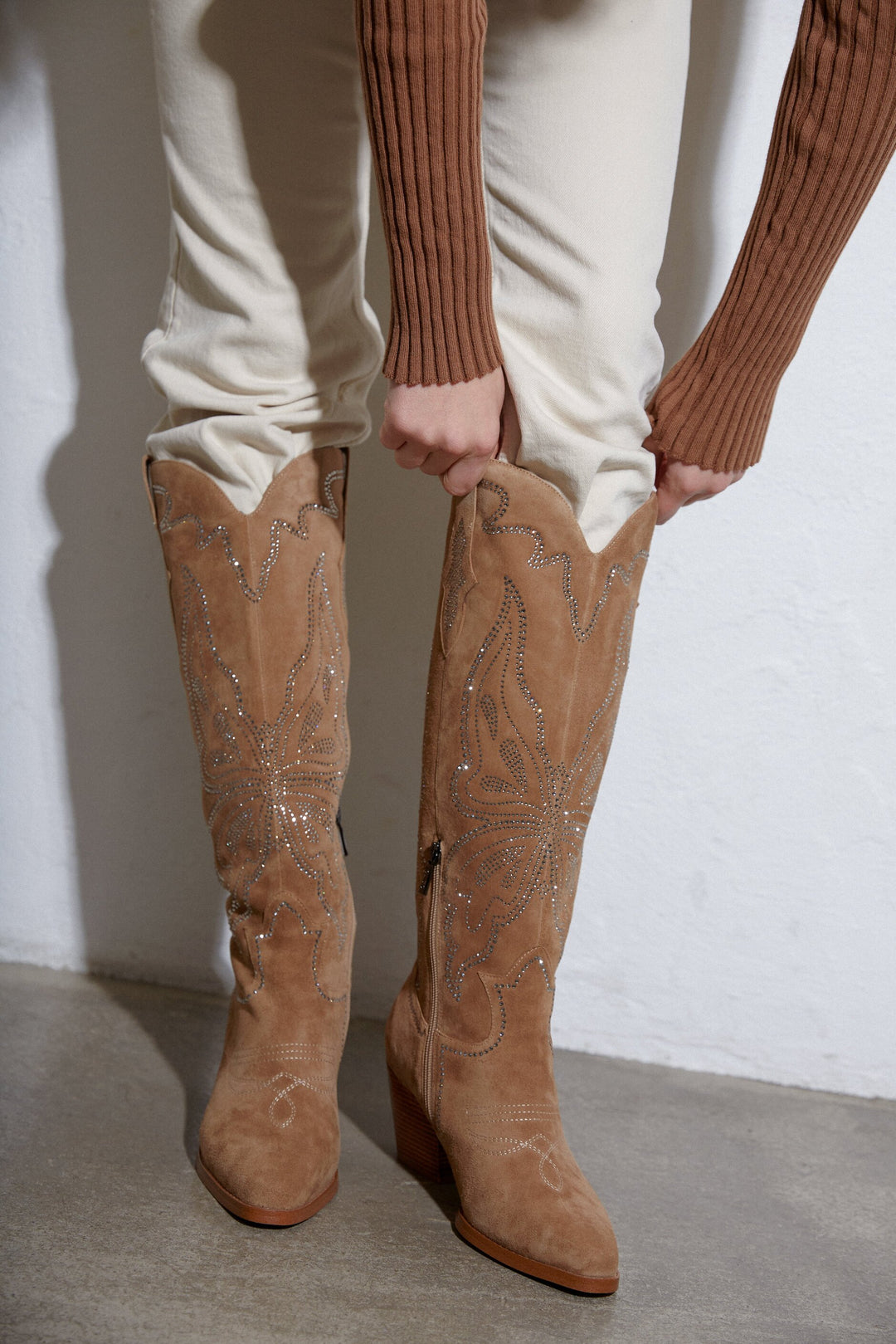 Women's cowboy boots with a high upper in beige by Estro - presentation on a model.