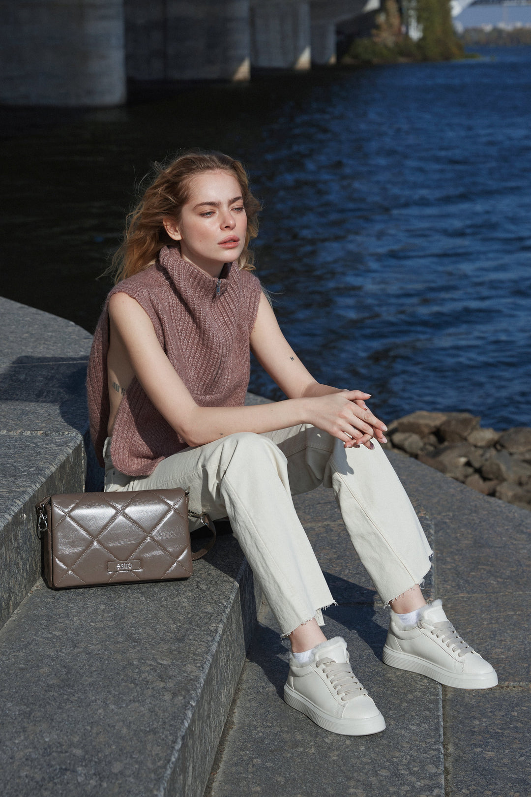 Estro's women's brown leather bag - presentation of the model in a complete outfit.