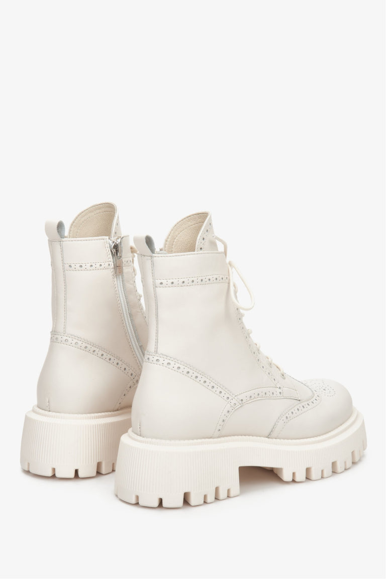 Women's white leather ankle boots with decorative lacing - close-up of the side and heel lines of the boots.