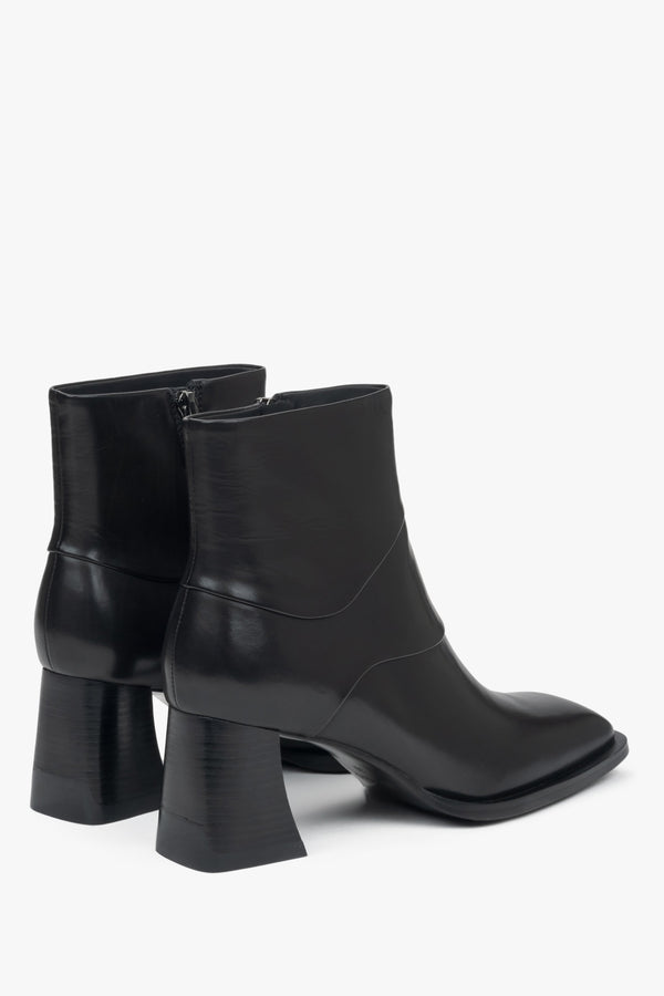 Classic black women's ankle boots made of natural leather with a comfortable block heel by Estro – close-up of the heel and side line of the shoes.