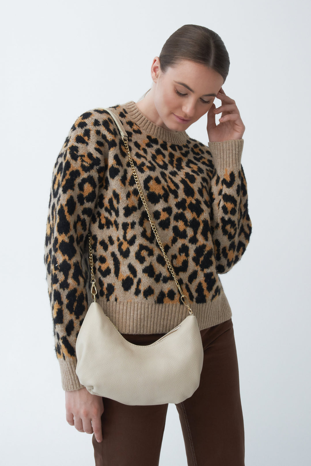Women's small baguette-style handbag in light beige genuine leather by Estro - showcased on a model.